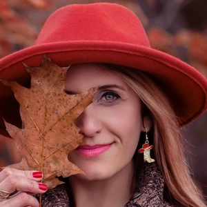 Detail shot of red cowboy hat and rhinestone boot dangle earrings on female model