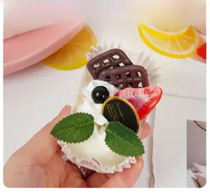 Handheld view showing the size and detail of a realistic fruit cupcake decoration