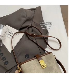 Detail of vintage patchwork crossbody bag featuring brown leather trim and gold buckle