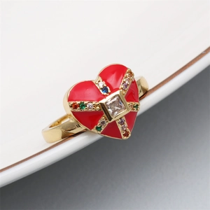 Macro detail of red heart enamel ring with gold plating and colorful zircon stones