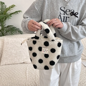Gros plan du sac sherpa à pois avec fermeture zippée et étiquette de marque colorée