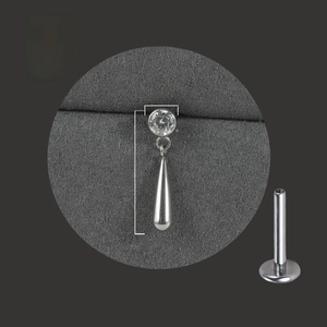 Macro detail of G23 titanium labret stud with 4mm zircon and 17mm teardrop pendant