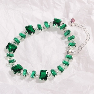 Close-up of green emerald-cut zircon bracelet with silver chain and adjustable clasp