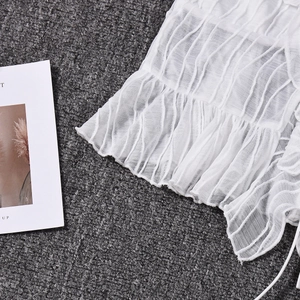 Detail of white pleated fabric texture with ruffle hem and delicate mesh structure