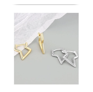 Detailed shot of irregular star and lightning bolt hoop earrings in gold and silver finish
