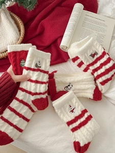 Detailed view of plush Christmas socks with cartoon snowman and tree embroidery