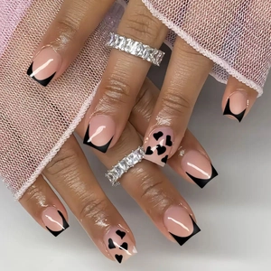 Classic black French heart press-on nails in medium square shape on a hand model