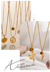 Detail of vintage gold flower necklaces on silk and stone featuring rose and tulip motifs