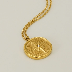 Detailed close-up of golden octagonal star pendant necklace with a sparkling zircon stone