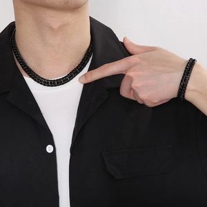 Close-up of matte black double weave Cuban chain necklace and bracelet set on model
