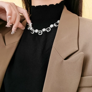 Détail d'un collier de pierres précieuses noires carrées avec des cristaux brillants
