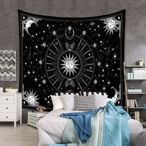 Detail of bohemian black and white tapestry with sun, moon, and astrology patterns on wall