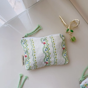 Détail de la pochette en toile florale avec motifs de vigne et étiquette Simple Wish
