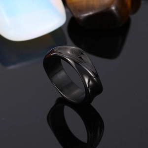 Macro view of a glossy black irregular wavy ring with sleek obsidian-like polished finish