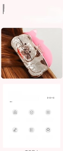 Detail of a pink and white cat-shaped hair claw clip on long brown hair in a French style