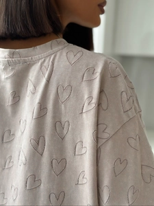 Détail de la texture en maille et motif de cœur sur un t-shirt gris décontracté