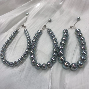 Detail of dark grey peacock pearls with metallic luster and adjustable silver chain
