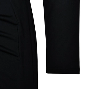 Detailed close-up of the black knitted fabric texture and sleeve stitching of the dress