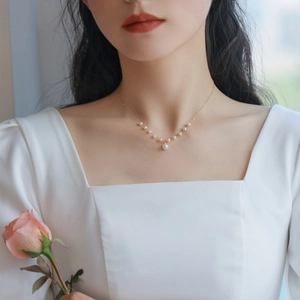 Elegant gold-plated chain necklace with white freshwater pearl pendant shown on model