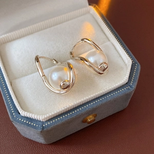 Detailed macro view of French vintage twisted earrings with white pearls in jewelry box