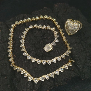 Macro shot of hip-hop gold heart necklace and ring set with sparkling crystals