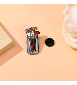 Detail shot of colorful enamel paintbrush jar pin with alloy dripping oil finish