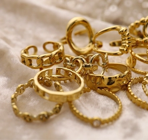 Macro view of gold plated stainless steel ring set on cream velvet fabric
