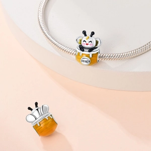 Detail showing a cute honeybee in a honey pot charm made of silver and yellow enamel