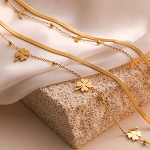 Double-layered 18k gold plated stainless steel clover necklace on silk background