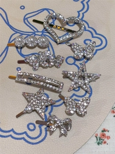 Detailed flat lay of Y2K rhinestone hair clips with heart, star and butterfly motifs