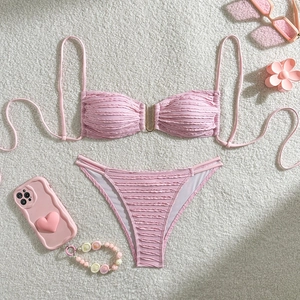 Detail of pink textured bikini top with golden U-link hardware and matching side-tie bottoms