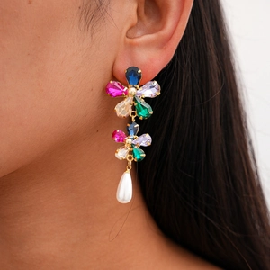 Detailed view of model wearing gold-plated floral earrings with pearls and colorful crystals