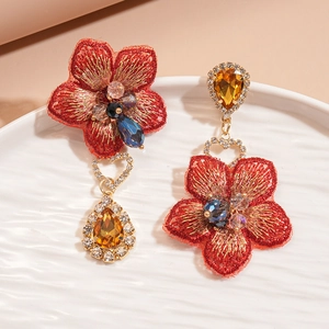 Détail de boucles d'oreilles fleurs en tissu vintage avec strass et cristal ambré