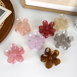 Jelly transparent floral hair claw clips in multi-colors arranged on white desk