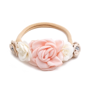 Detail of pink and white fabric roses with pearl beads on an elastic baby headband