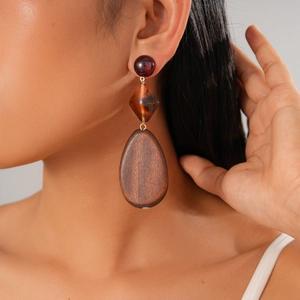 Close-up of bohemian wood bead drop earrings on model in retro dark brown style