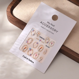 Détail de stickers nail art floraux avec perles et cadres dorés sur carte de présentation