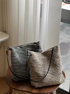 Gros plan de sacs cabas en tricot à rayures posés sur un tabouret en bois près d'une fenêtre