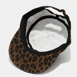 Détail de l'intérieur de la casquette léopard montrant l'étiquette 100% coton et les coutures