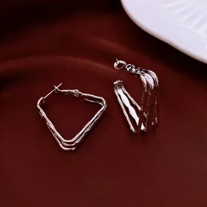 Minimalist square geometric silver plated earrings with textured lava design on red silk