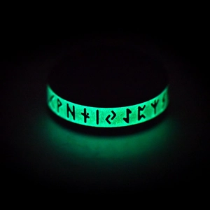 Macro shot of glow in the dark Viking rune ring spinning feature with green light