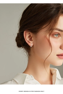 Close-up of S999 sterling silver Mobius hoop earring on model for a minimalist fashion look