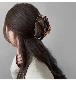 Macro detail of large tortoiseshell shark clip holding a neat updo hairstyle