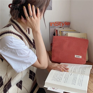 Bolsa de cosméticos de jacquard de pata de gallo roja en un escritorio muy acogedor