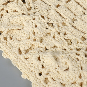 Vue macro du tissu au crochet bohème crème avec des motifs de dentelle ajourée