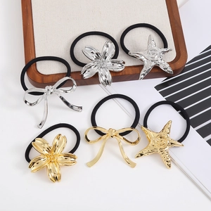 6-piece metallic hair tie set with cherry blossom, starfish, and bow charms on white tray