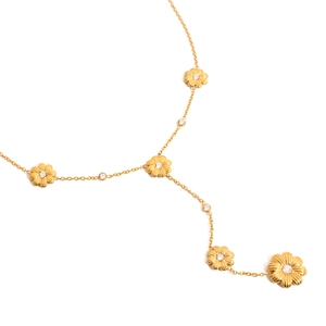 Détail d'une chaîne plaquée or 18 carats avec breloques marguerites et cristaux