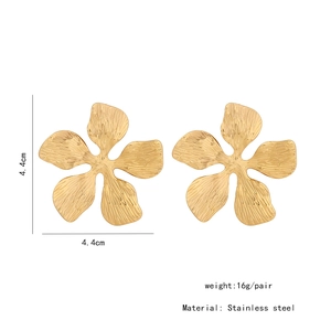 Macro detail of large gold flower stud earrings with 4.4cm size and stainless steel texture