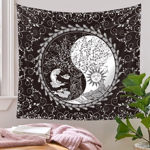 Detail of Bohemian black and white sun and moon mandala tapestry hung in a cozy home setting