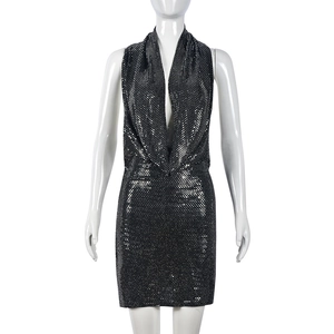 Détail d'une mini robe noire à paillettes avec dos nu et décolleté en V profond sexy